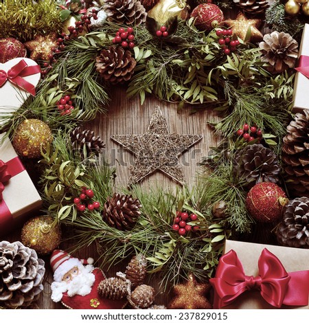 a rustic wooden table full of gifts, and christmas ornaments, such as a natural wreath with branches, berries and pine cones, or christmas balls and stars , with a retro effect