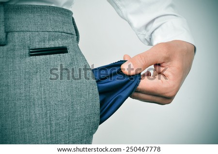 a broke businessman showing his empty pocket