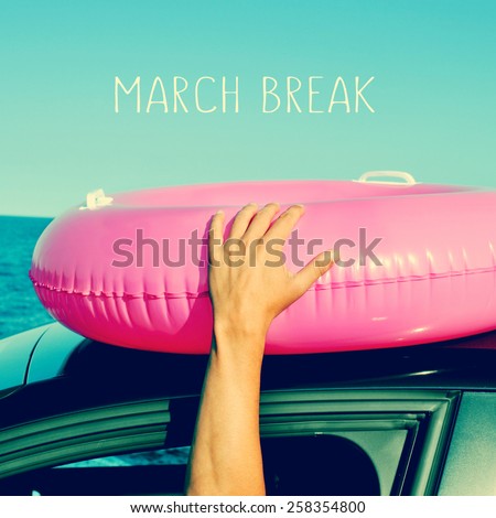 a young man holding a pink swim ring in the roof of a car near the ocean and the text march break written in the blue sky