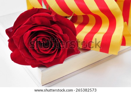 a red rose and the catalan flag on a book for Sant Jordi, the Saint Georges Day, when it is tradition to give red roses and books in Catalonia, Spain