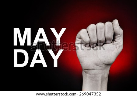 closeup of the raised fist of a young caucasian man and the text may day on a red background