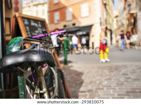closeup of a worn-out bicycle in a pedestrian street in Saint-Tropez, France, with a filtered effect