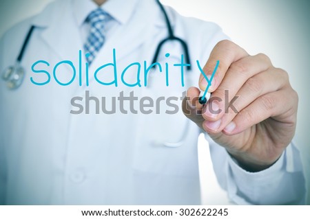 closeup of a young doctor writing the word solidarity in the foreground, for the concept of medical solidarity and aid