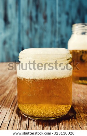 refreshing beer served in glass jars on a rustic wooden surface