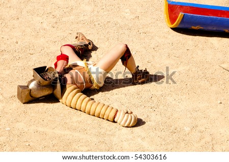 a gladiator lying on the arena of a amphitheater