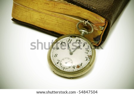 ancient book and pocket watch on a degraded background