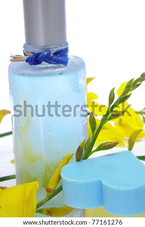 a bottle of fresh scent with flowers and heart-shaped soap on a white background