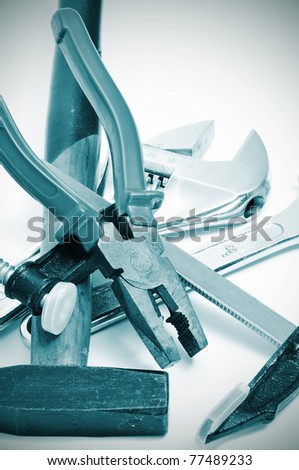 a pile of tools, as a hammer, pliers, adjustable spanner or bar clamp
