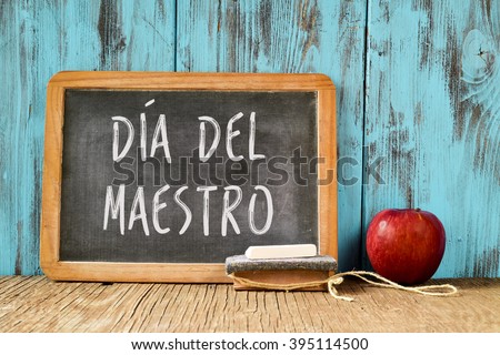 a chalkboard with the text dia del maestro, teachers day written in Spanish, a piece of chalk, an eraser and a red apple on a rustic wooden table, with a retro effect