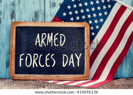 the text armed forces day written in a chalkboard and a flag of the United States, on a rustic wooden background