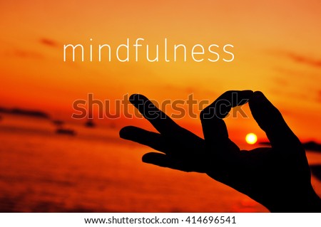 the text mindfulness and a closeup of a young man meditating with his hand in gyan mudra at sunset