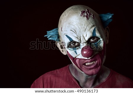 portrait of a scary evil clown against a dark background