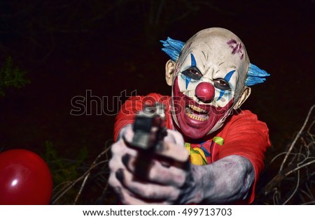 a scary evil clown pointing a gun to the observer in the woods, in the dark of night