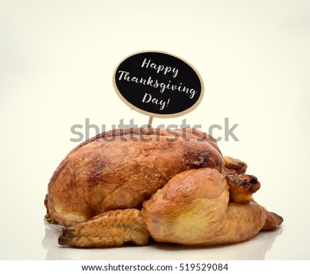 a roast turkey topped with a black signboard with the text happy thanksgiving written in it, on an off-white background