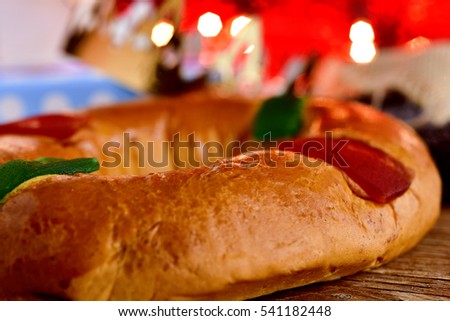 closeup of a roscon de reyes, the traditional spanish three kings cake eaten on epiphany day, on a rustic wooden table