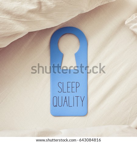 closeup of a blue door hanger with the text sleep quality written in it, placed on a comfortable bed