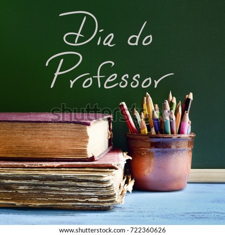 closeup of a chalkboard with the text dia do professor, teachers day written in Portuguese, a pile of old books and a pot with pencils on a rustic wooden table