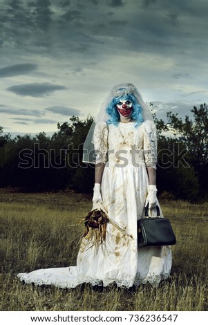 a scary evil clown wearing a dirty and ragged bride dress, and holding a bridal bouquet with wilted flowers and an old purse, in a disturbing rural landscape at dusk