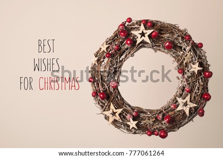 a nice wreath with red fruits and golden stars and the text best wishes for christmas on a beige background
