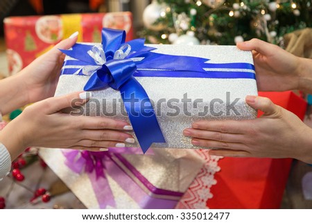 Two people giving gift box on Christmas during winter holiday.