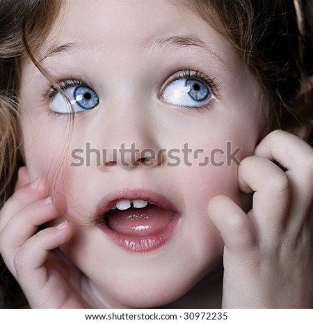 portrait of a pretty little girl with blue eyes looking sideways