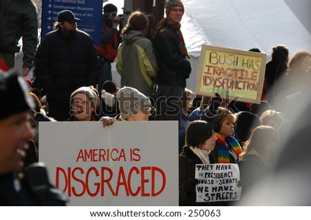 Protesters w/ signs, Washington, DC: America is disgraced; Bush has Iraq tile Dysfunction...