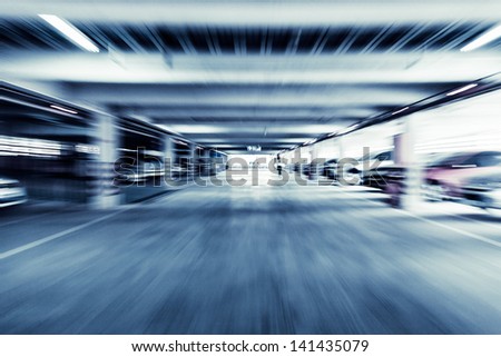 Parking garage, interior with a few parked cars.Motion blur