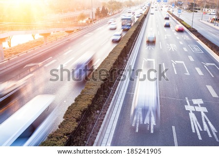 Cars in motion blur on street during sunset