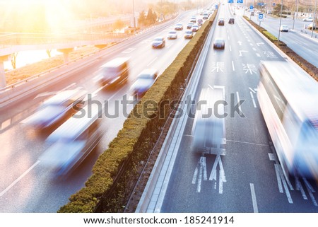 Cars in motion blur on street during sunset