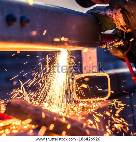 worker cutting steel pipe using metal torch and install roadside fence