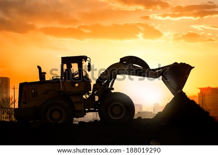 heavy wheel excavator machine working at sunset