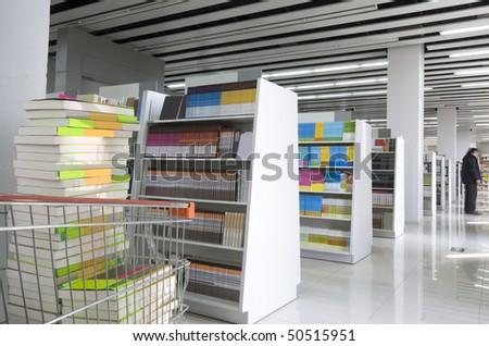 The aisles in a public library with shelves full of books
