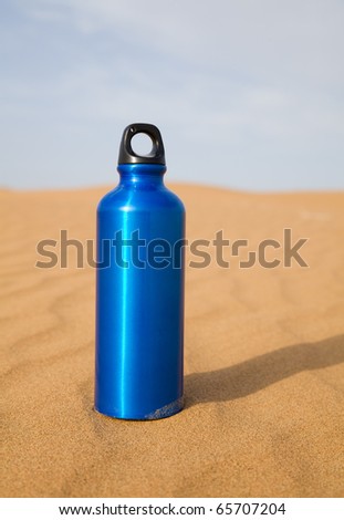 Blue sport water bottle in desert