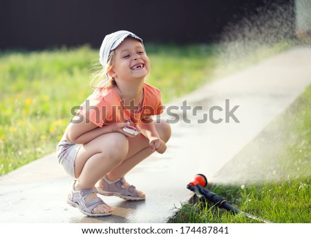 toothless smiling girl watering the grass