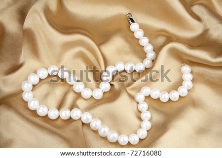Beads from pearls on gold silk