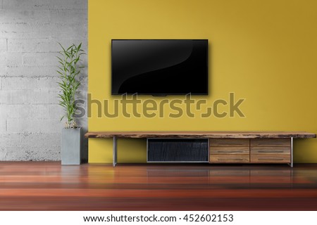 Living room led tv on yellow wall with wooden table and plant in pot modern loft style