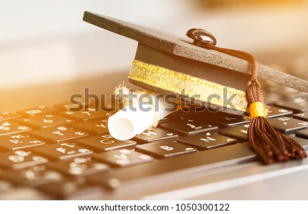 E-learning online graduate education concept : Graduation cap, certificate degree on laptop computer that can learn distant by internet, it selection of appropriate multimedia enhance learning.