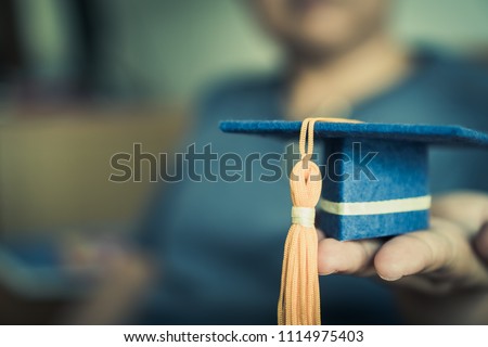 Graduation cap on hands show success in education learning study international abroad \with blur students,  copy space for design. Back to School
