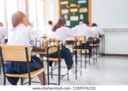 Exam for Education uniform students testing exams with pencil for multiple-choice quizzes or test answer sheets exercises in school rows chairs at classroom in Thailand, Behind Asian back to school