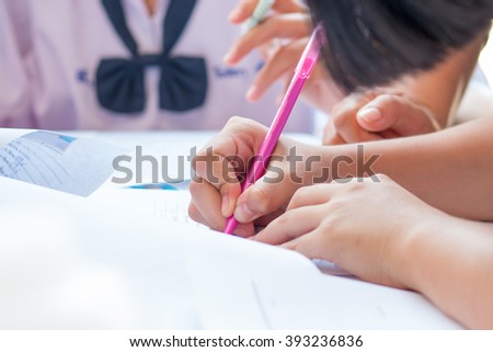 Thai students writing on a paper for Admissions in high school, Thailand
