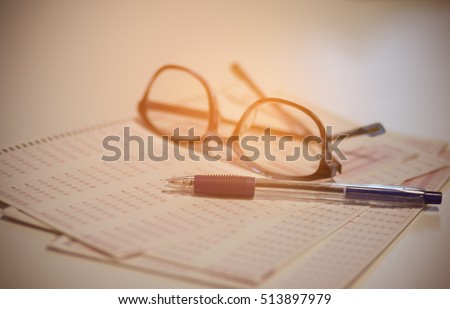 optical form of an examination with pen and glasses, filling a standardized test form, vintage tone