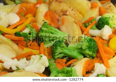 Vegetables mix (closeup of fried new potatoes with vegetables: auliflower, broccoli, garlic, carrot, red pepper etc )