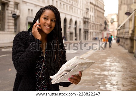 young woman on the phone holding a map.