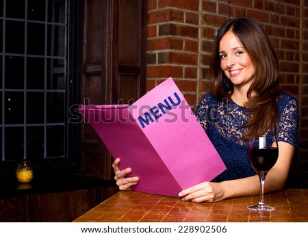 a young lady holding a menu in a bar