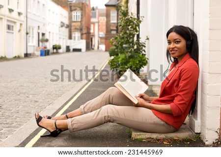 young woman reading a book and listening to music.