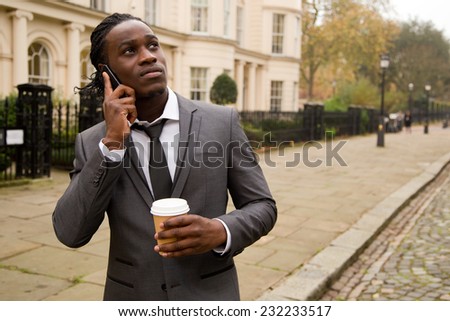 business man on the phone holding a coffee in the street