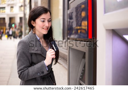 young woman showing her card at the cash machine.