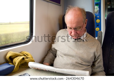 man reading newspaper on the train