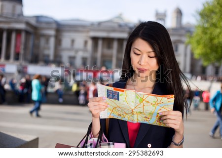 young chinese tourist reading a map in London