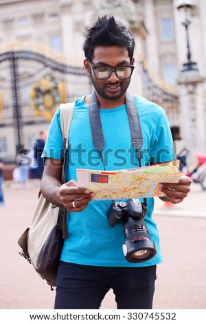 tourist at Buckingham palace reading a map